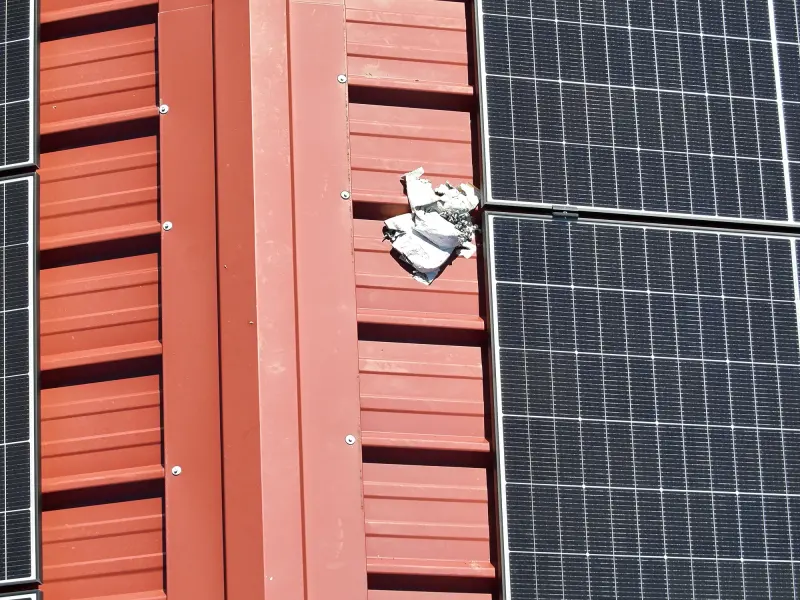 Ziegeldach mit PV-Modulen und Blechdach aus nächster Nähe von oben